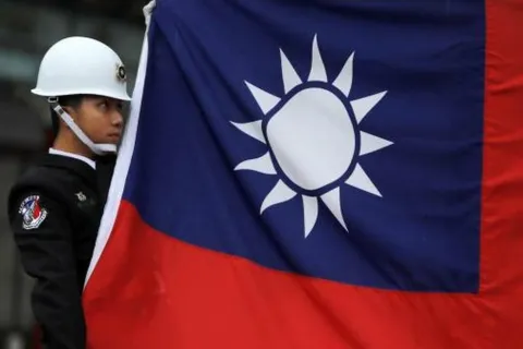 FILE PHOTO: A military honour guard holds a Taiwanese national flag as he attending flag-raising ceremony at Chiang Kai-shek Memorial Hall, in Taipei, Taiwan March 16, 2018. REUTERS/Tyrone Siu